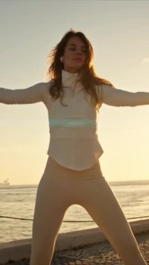 Tagus nehrinin orada, Lizbon 'da Tai Chi Chuan pratiği yapan genç bir kadın.