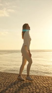 Gün batımında neşeyle dans eden enerjik bir kadın.