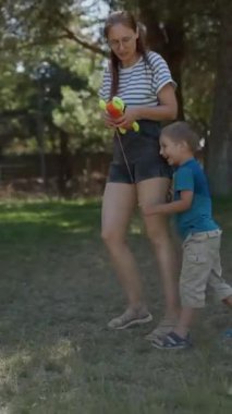 Bir yaz parkında birlikte oynarken annesinin peşinde koşan küçük mutlu bir çocuk.