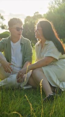 Parkta güneşli bir günde sohbet eden mutlu bir çift.