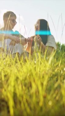 Çiftler doğada huzurlu bir anın tadını çıkarıyor, içkilerini ve sohbetlerini paylaşıyorlar.