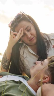 Romantik lezbiyen çift doğada rahatlatıcı bir anın tadını çıkarıyor, işaret diliyle sevgilerini ifade ediyorlar.