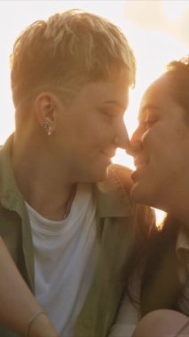 Genç lezbiyen bir çiftin güneşli bir alanda sevgisini paylaştığı romantik anlar.