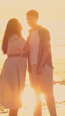 Romantik lezbiyen çift gün batımında sahilde yürüyüş yapıyor, özel anlarını paylaşıyorlar.