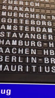 Black analog departure scoreboard at the airport. Mid shot