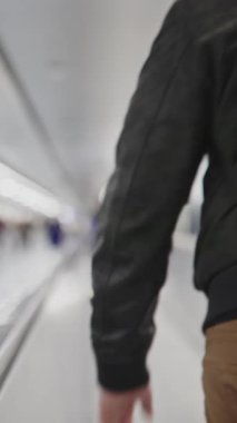 People walking on the moving walkway in the airport - blurred footage. Mid shot