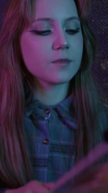 Stüdyoda mavi ve pembe ışıklandırmalı davul çalan hoş bir genç kadın. Portre