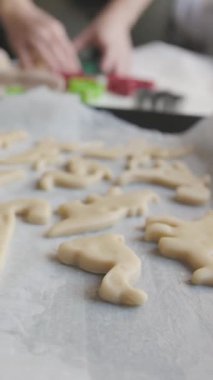 Hamur hamuru, kurabiye kağıdındaki dinozor şeklindeki kurabiyeler için. Yakın plan.