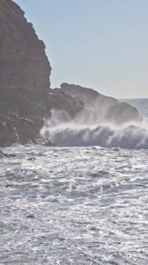 Deniz köpüren dalgalar kayalara çarpar. Orta çekim