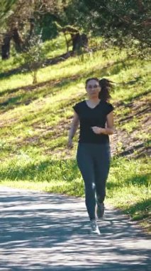 Yetişkin sporcu kadın parkta koşuyor. Orta çekim