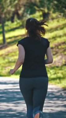 Yeşil parkta koşan yetişkin bir kadın. Orta çekim