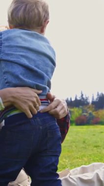 Parkta küçük oğlu olan sevimli bir anne. Orta çekim