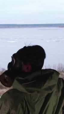 Kıyamet sonrası konsepti. Gaz maskeli bir adam terk edilmiş binada dikilip etrafa bakıyor. Orta çekim