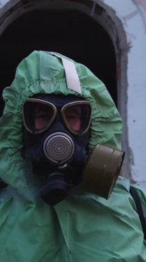 Kıyameti andıran bir kavram. Gaz maskeli bir adam koruyucu kıyafet giyiyor. Portre