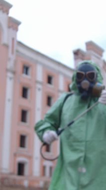 Kıyamet sonrası konsepti. Gaz maskeli, koruyucu giysili, kimyasal spreyli bir adam öne eğilip kameraya bakıyor. Portre