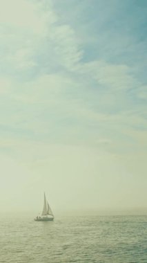 Yelkenli yoğun siste denize açılır. Gökyüzünde bir uçak uçar. Orta çekim