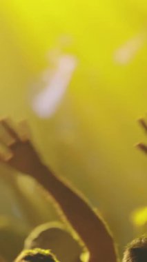 İnsanlar canlı konserlerde kollarını yana doğru sallıyorlar. Orta çekim