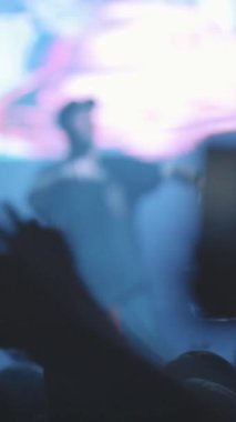 Canlı konserin seyircisi ellerini sağa sola sallıyor ve şovu telefonlarından çekiyor. Orta çekim