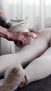 Kadın kalçalarına ve bacaklarına, vücut şekillendirme ve selülit azaltma için lpg masajı yapan profesyonel bir güzellik uzmanı.