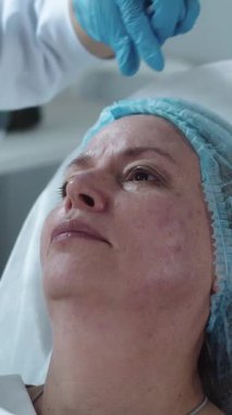 Yetişkin bir kadın için burun köprüsüne yapılan güzellik iğneleri. Orta çekim