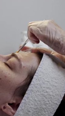 Profesyonel güzellik uzmanı cilt tedavisi için genç kadınların yüzüne kimyasal kabuk takıyor.