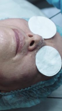 Kozmetik tedavisi. Doktor ameliyattan önce hastaların gözlerine koruyucu diskler takıyor. Orta çekim