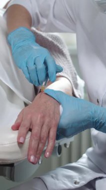 Kozmetoloji uzmanı kadın elinin derisinin altına güzellik enjeksiyonu yapıyor. Orta çekim