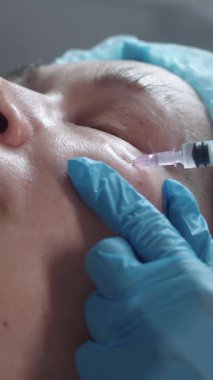 Kozmetik tedavisi. Yetişkin bir kadın için elmacık kemiklerine güzellik iğneleri. Orta çekim