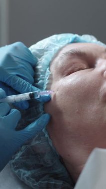 Yetişkin bir kadın için elmacık kemiklerine güzellik iğneleri. Orta çekim