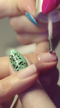 Manikürcü, müşterilerin tırnaklarına çıplak jel tabanı uygular. Orta çekim