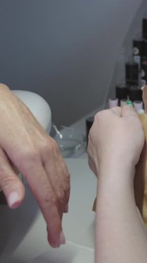 Manikür prosedürü. Usta kese kağıdından yeni aletler çıkarır. Orta çekim