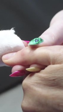 Manikür - usta müşterinin tedavi edilmiş tırnak plakasını siler. Orta çekim