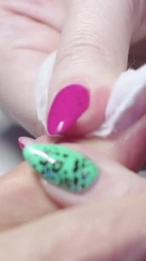 Manikür. Usta, müşterinin tırnak altlığını pamukla siler. Kapat.