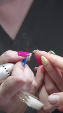 Manikür, usta müşterilerin parmaklarını aleti kullanarak işliyor. Orta çekim