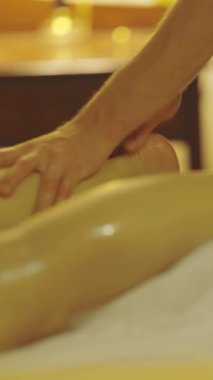 Masaj seansı - uzman terapist müşterilerinin bacaklarına masaj yapar. Orta çekim