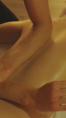 Masaj seansı. Önkollu, yağlı, çıplak bir kadın müşteriye masaj yapmak. Orta çekim