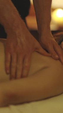 Gülümseyen rahat kadın, SPA salonunda sırt masajı yaptırıyor. Orta çekim