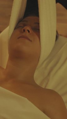 Masaj prosedürü. Masör, kadınları havluyla kenara çeker. Orta çekim