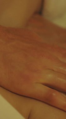 Spa salonundaki bir kadının omzuna masaj yapan bir adam. Orta çekim