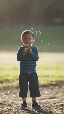 Oyun oynayan ve sabun köpüğü yakalayan sevimli bir çocuk. Orta çekim