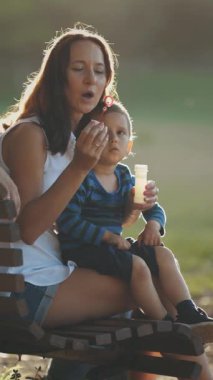 Aile parkta sabun köpüklerini üfleyerek vakit geçiriyor. Orta çekim