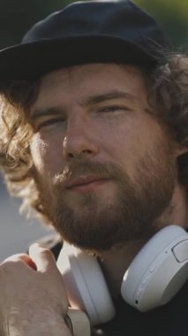 Sokakta kameraya bakan gitarlı genç bir adamın portresi. Portre