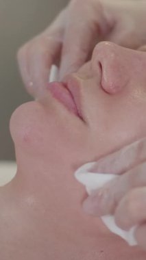 Bir kozmetikçiyle seans. Terapist, ameliyattan sonra müşterilerin yüzünü siliyor. Orta çekim