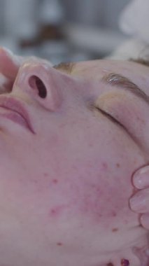 Bir dermatologla seans - terapist müşteriye yumuşak bir yüz masajı yapar. Orta çekim