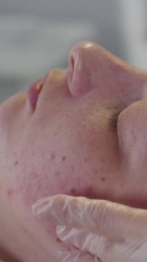 Bir dermatologla seans - terapist bayan müşterisi için yumuşak bir yüz masajı yapar. Orta çekim