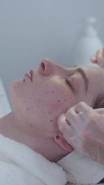 Kozmetik tedavisi. Usta, ameliyattan sonra hastaların derilerini pamukla siler. Orta çekim