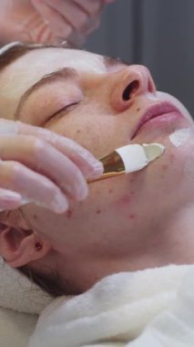 Kozmetik uzmanının cilt bakımı. Usta, müşterilerin yüzüne fırçayla maske takıyor. Orta çekim