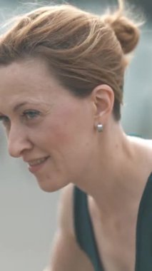 Makyajsız, elleri ağırlık kaldıran yetişkin bir kadının portresi. Orta çekim