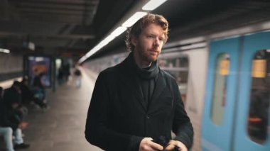 Sakallı düşünceli bir adam her gün metroda trenini bekliyor.
