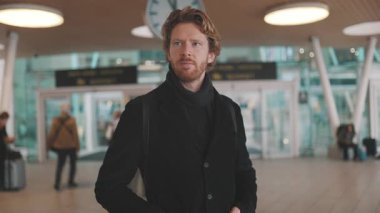 Yoğun bir toplu taşıma istasyonunda sırt çantalı ya da trenini bekleyen kendinden emin bir adam.